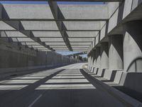 the underpass on a bridge runs along the roadway near an empty parking lot area