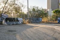 a group of graffiti covered barricades at an abandoned park, including one with a graffiti - spray on it