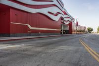 the red wall has the large sign above it on the side of the building and road