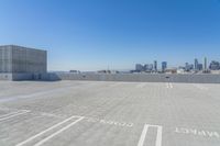 a parking lot with no people on it with skyscrapers in the background and a city view