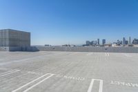 a parking lot with no people on it with skyscrapers in the background and a city view