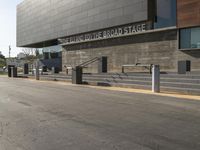 an asphalt street with a bike rack, parking meters and an open road with stairs