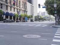 an empty road with lots of cars moving by it and a tall building in the background