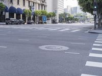 an empty road with lots of cars moving by it and a tall building in the background