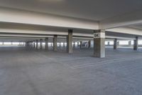 an empty parking garage with a lot of floor and walls, showing no standing signs