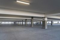 an empty parking garage with a lot of floor and walls, showing no standing signs