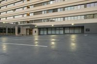 a large building with some windows and doors in a parking lot with an umbrella on it