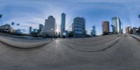 a fisheye lens picture of some buildings and trees on the street corner of this city