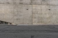 the corner of an industrial concrete wall has a large hole in it and several lights are on