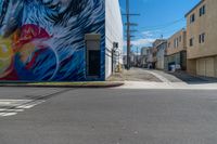 the side of the building is a painted mural depicting a man with a surfboard