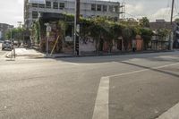 the street is full of small buildings and empty street lights and traffic signs in the distance are on buildings