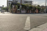 the street is full of small buildings and empty street lights and traffic signs in the distance are on buildings