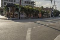 the street is full of small buildings and empty street lights and traffic signs in the distance are on buildings