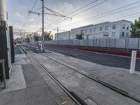 a train and several buildings and tracks on a city street near the ocean shore in california