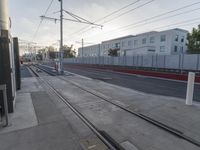 a train and several buildings and tracks on a city street near the ocean shore in california