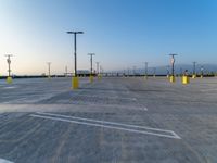 empty parking lot with parking lights and a streetlight in the distance to the right