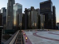 buildings in the foreground and walkway to the right of them, surrounded by a circle, at dusk