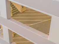 a view of the top of the staircase through an atrium door from above, looking down