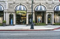 a store with a lot of windows next to it on the side walk of a street