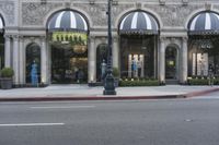 a store with a lot of windows next to it on the side walk of a street