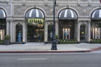 a store with a lot of windows next to it on the side walk of a street