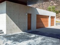 a gray concrete building with stairs and door at the top of the floor next to it is steps leading down to the doorway