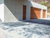 a gray concrete building with stairs and door at the top of the floor next to it is steps leading down to the doorway