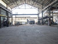 a view of an old factory area in a warehouse building, which has the doors open and the ceiling wide