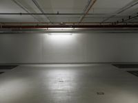 large empty warehouse with light on the floor in it's garage area, waiting for customers