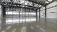 an empty warehouse space with lots of light and glass walls on the ceiling and high ceilings