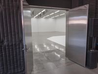 open door that leads to the inside of a commercial space with grey walls and white flooring