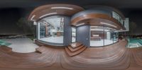 a fish eye lens shows a circular wooden house with a hot tub and a large indoor pool