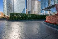 the street is paved with black stone and is surrounded by buildings with lots of trees