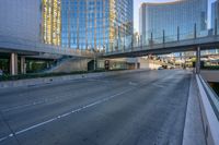 a bus is going down a street next to a high rise building with multiple levels