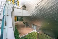 a view of the entrance to an outside building from another room below a glass and steel staircase