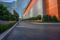 a wide road is surrounded by orange walls and tall skyscrapers near the water front