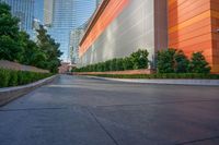 a wide road is surrounded by orange walls and tall skyscrapers near the water front