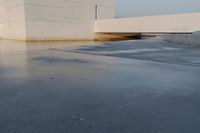 the building is next to the water under the bridge and a stop sign stands in a puddle of water