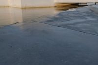 the building is next to the water under the bridge and a stop sign stands in a puddle of water