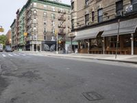 a view of an empty city street with parked cars and buildings in the background in new york city