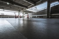 a view into the top level of an empty building with multiple red traffic cones on it