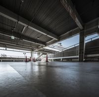 a view into the top level of an empty building with multiple red traffic cones on it