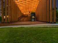 a wooden structure with stairs inside of it in the evening light with dark clouds overhead