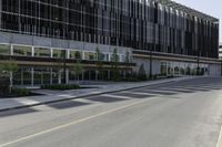 a tall building sitting on the side of a road with lots of windows and no one is wearing shoes