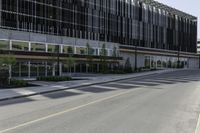 a tall building sitting on the side of a road with lots of windows and no one is wearing shoes