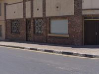 a building with the sign that reads to the right of the road is a closed street, with a yellow line on the road in front of it, and some buildings