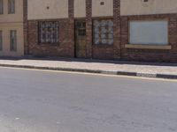 a building with the sign that reads to the right of the road is a closed street, with a yellow line on the road in front of it, and some buildings