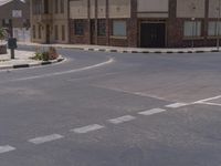 a building with the sign that reads to the right of the road is a closed street, with a yellow line on the road in front of it, and some buildings