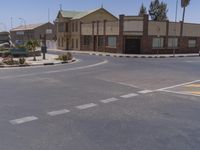 a building with the sign that reads to the right of the road is a closed street, with a yellow line on the road in front of it, and some buildings