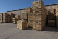 a large number of boxes and pallets for storage in an open space area, near a building